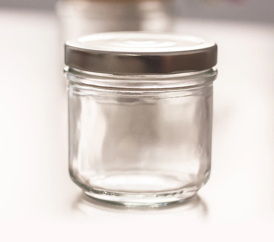 Empty clear glass jar with a silver metal lid