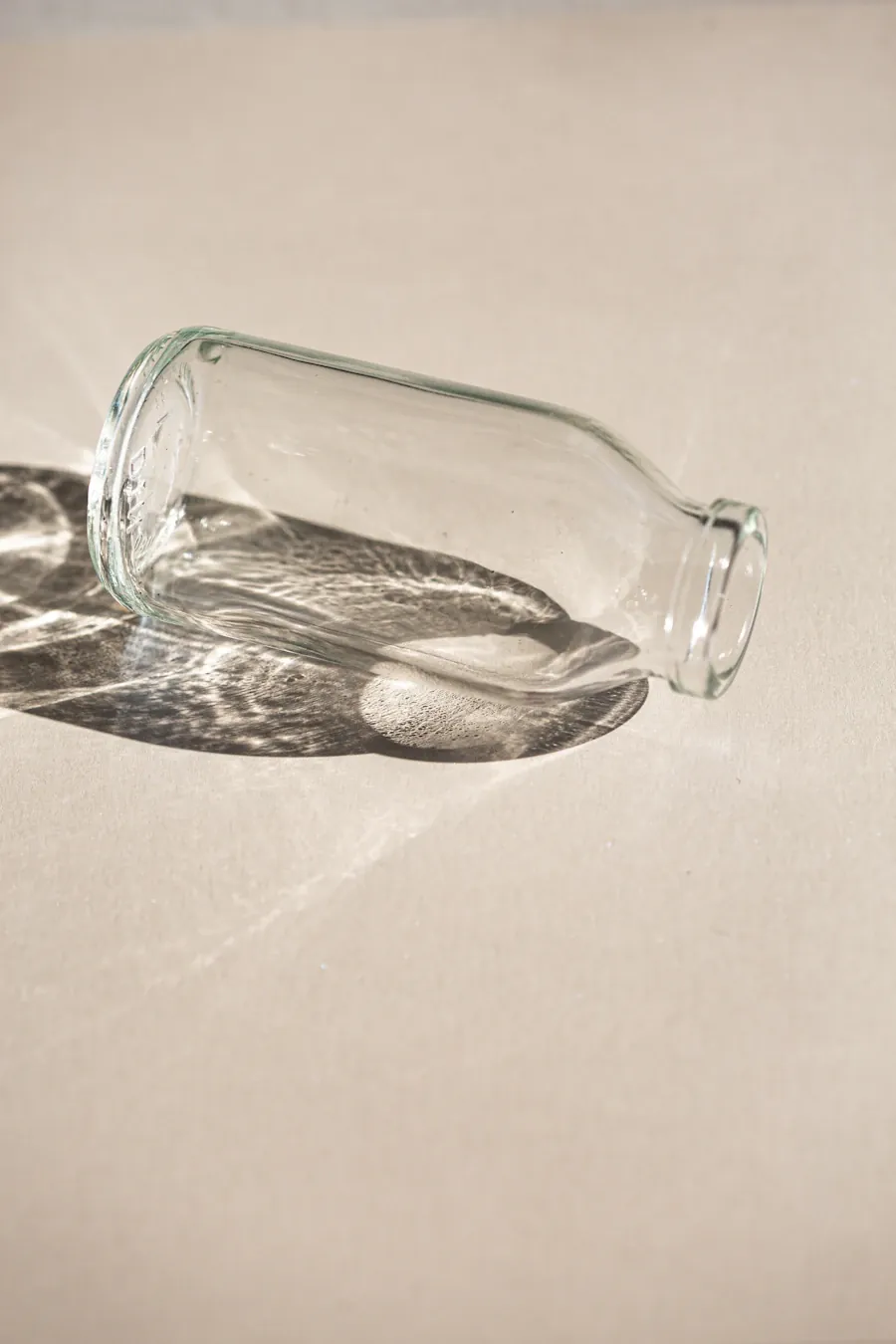 Clear glass bottle with light refraction shadow